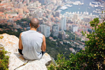 Fototapeta na wymiar Young man on a hill above Monaco, contemplating the view