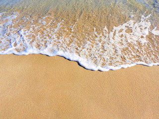 Sand on the beach. Close-up of sand and surf with copy space. Focus on the foreground. Sand background. 