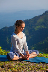 Naklejka na ściany i meble Sporty fit woman practices yoga asana Baddha Konasana outdoors