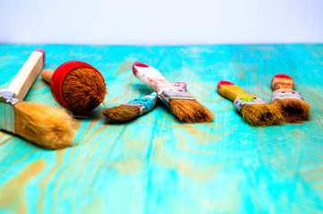 Painting brushes on blue wooden table