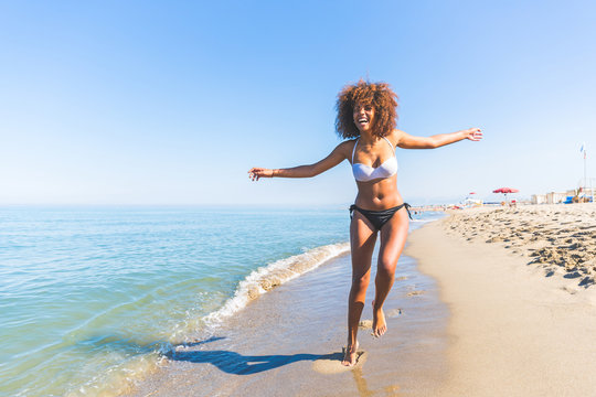 Young black woman having fun at seaside