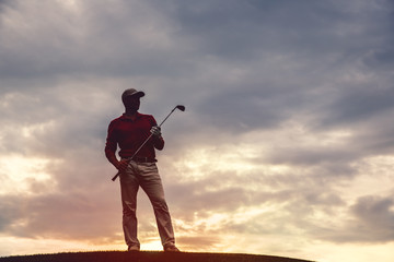 silhouette of man golfer with golf club at sunset