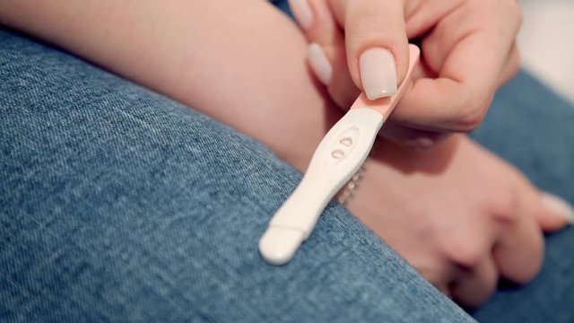 Woman Holding Positive Pregnancy Test. Close-up. RAW video record.