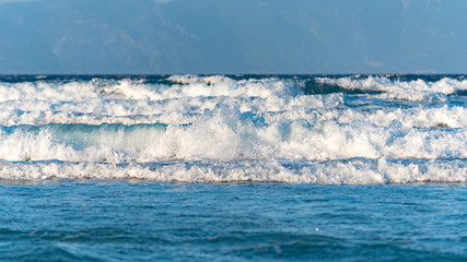Sea waves crushing on the coast with Mount Athos in the background