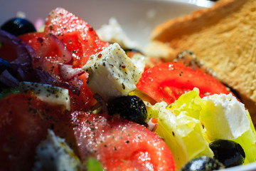 Fresh greek salad with grilled bread for healthy lunch.
