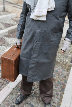 poor immigrant with old leather suitcase