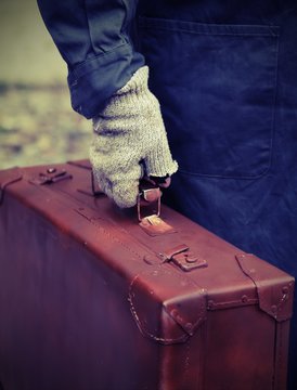 poor person with the old worn leather suitcase in search of work