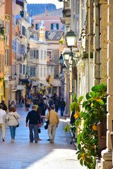 Corf old town narrow streets. Tourists walking down the old prom