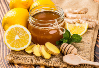Honey comb, fresh lemon and ginger on a wooden table