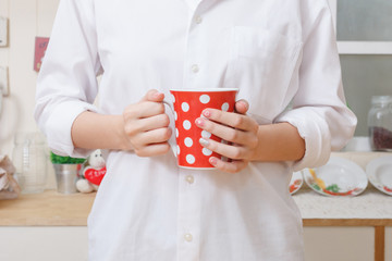 woman holding red cup coffee on hands