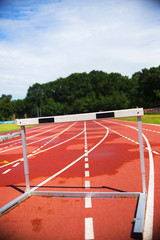 red running athletic track with hurdle, bad weather, wet