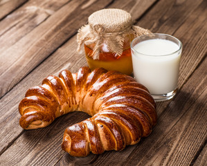 Tasty croissants with spikelets on grey wooden background