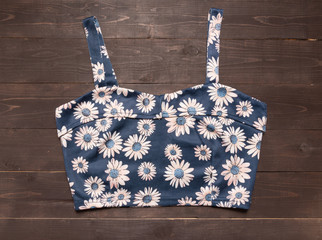 Floral vest is on the wooden background