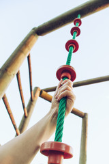 Llega a lo más alto con tu esfuerzo. Mano de alguien escalando una cuerda. Primera persona