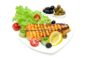 piece of baked salmon with lemon and vegetables on the plate on