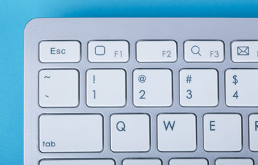 Computer keyboard on blue background
