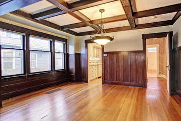 Empty room with wood paneled walls and coffered ceiling.