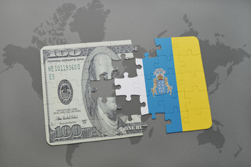 puzzle with the national flag of canary islands and dollar banknote on a world map background.