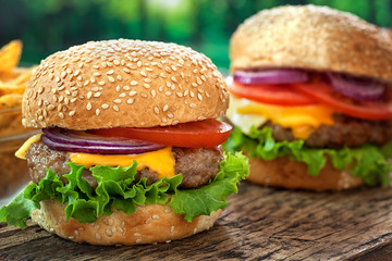 Cheeseburgers on wooden table with copy space