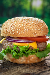 Cheeseburger on wooden table with copy space