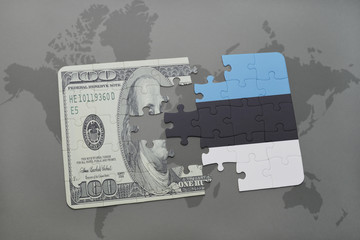 puzzle with the national flag of estonia and dollar banknote on a world map background.