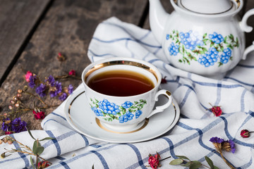 still life with tea cup and tablecloth on wooden table