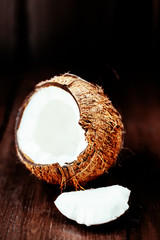 Coconut over dark background. Close up of coco nut on a wooden t