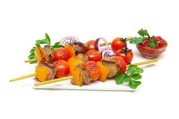 skewers of meat with vegetables on a white background