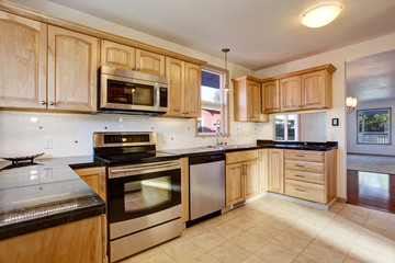 Practical kitchen room with light tones cabinets and steel appliances.