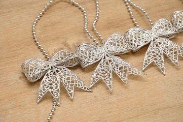 Silver bows isolated on a wooden background