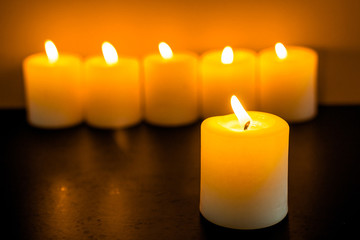 closeup to burning candles in darkness