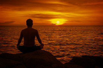 Man meditating at sunset. Tropical beach of Thailand