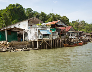 Fototapeta na wymiar Old houses on river bank. Thailand