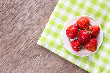 Strawberries on checkered napkin.