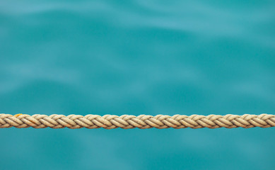 Thick ship rope on the sea water background