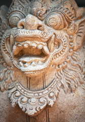 Muzzle of terrible mythical monster. Stone statue from Indonesia