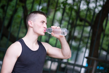 Handsome athlete man drinking water