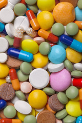 Pile of colorful medications tablets - medical background