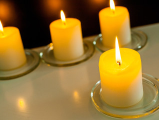 closeup to burning candles in darkness