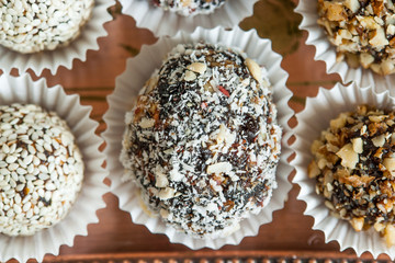 Homemade candy with prune, peanut and coconut flakes on copper t