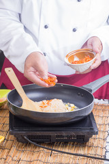 Chef putting dried shrimp to pan