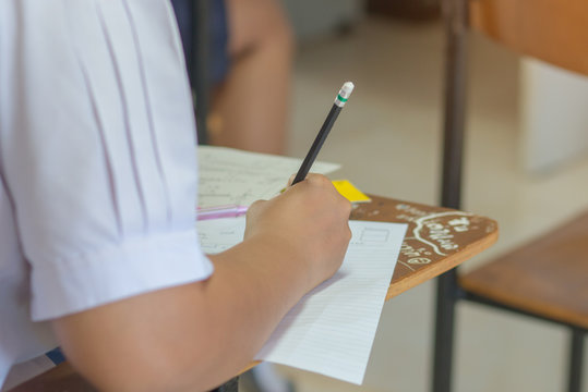 Asian students reading and writing a test in test paper, exercis