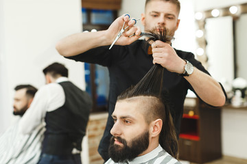 Dark haired barber doing a haircut
