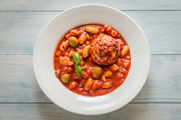 Portion of minestrone soup with meatball