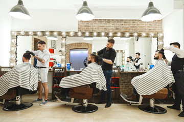 Barbers doing haircuts for clients