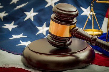 American flag, a golden scale and a judge's gavel symbolizing the American justice system or the...