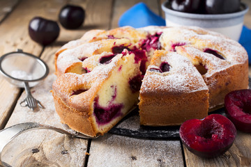 Plum cake on an old wooden table. Rustic style. Selective focus.