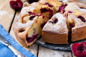 Plum cake on an old wooden table. Rustic style. Selective focus.