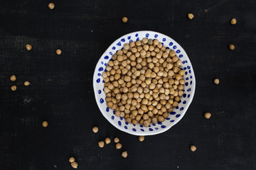 Chickpeas in a white ceramic bowl on a black background