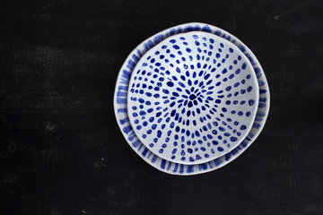 Two blue and white ceramic bowls on a black background